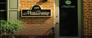Brick building facade with "Moore Cleaning Commercial Services" sign and glass door displaying the same name and number 209.